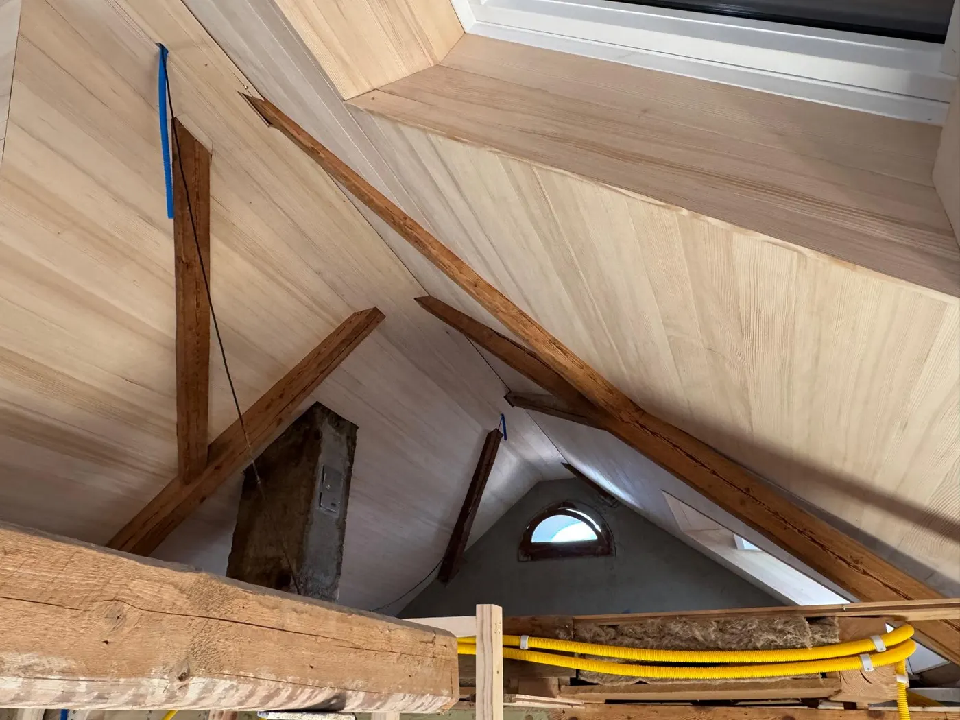 Ausgebauter Dachstuhl mit sichtbaren Altholzbalken und neuem Täfer